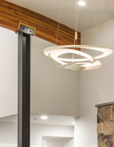 Modern interior showing a circular pendant light hanging from the ceiling, with stone and wood elements in the design.